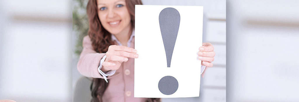 Woman holding up a poster with exclamation point