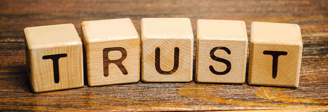 The word "trust" spelled out in wooden blocks