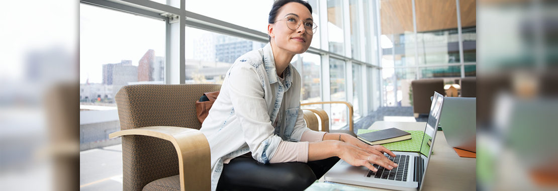 woman at computer smiling and looking off