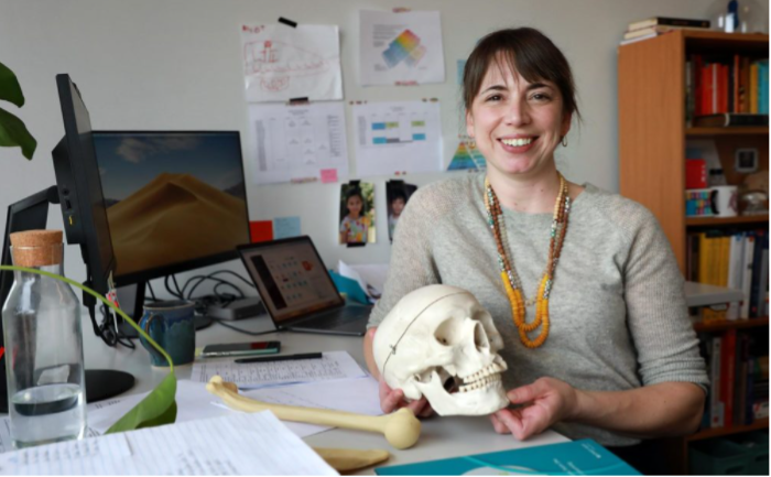 Liz Co holding model skull in her office