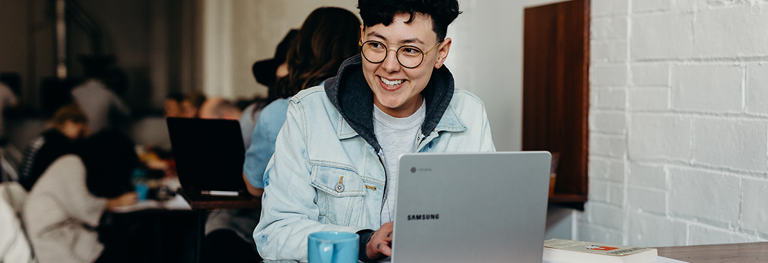 student at laptop smiling