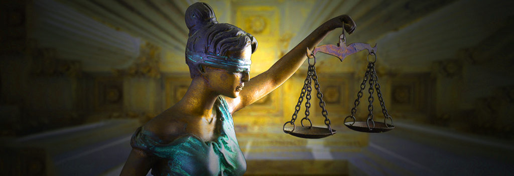 Statue of a blindfolded woman holding a pair of scales, which commonly represents the justice system.