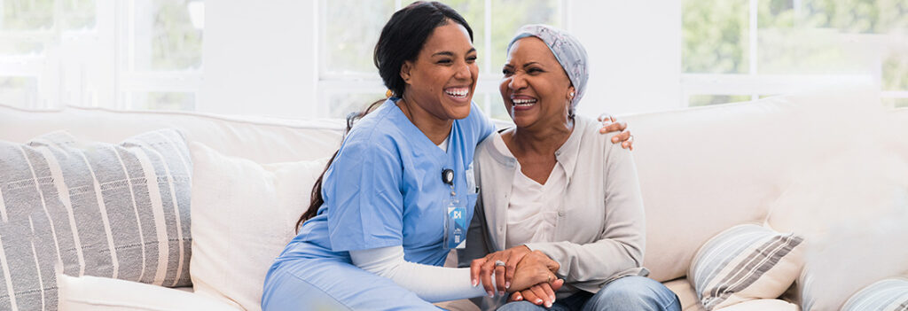 Healthcare worker and patient smile while sitting and hugging