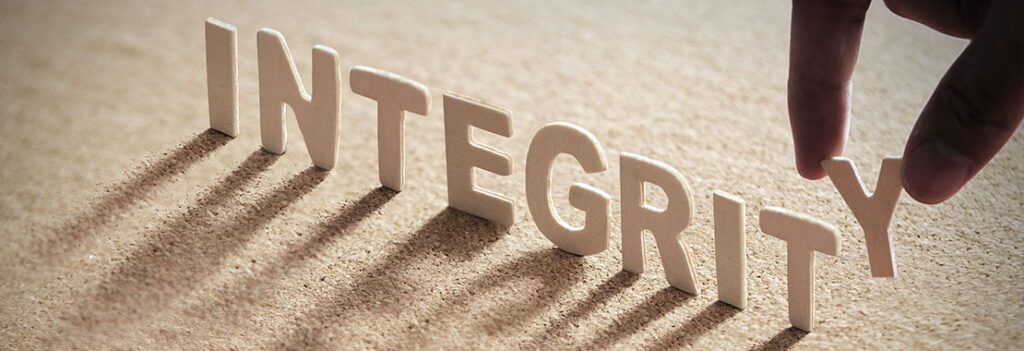 integrity in standing letters across table casting shadow