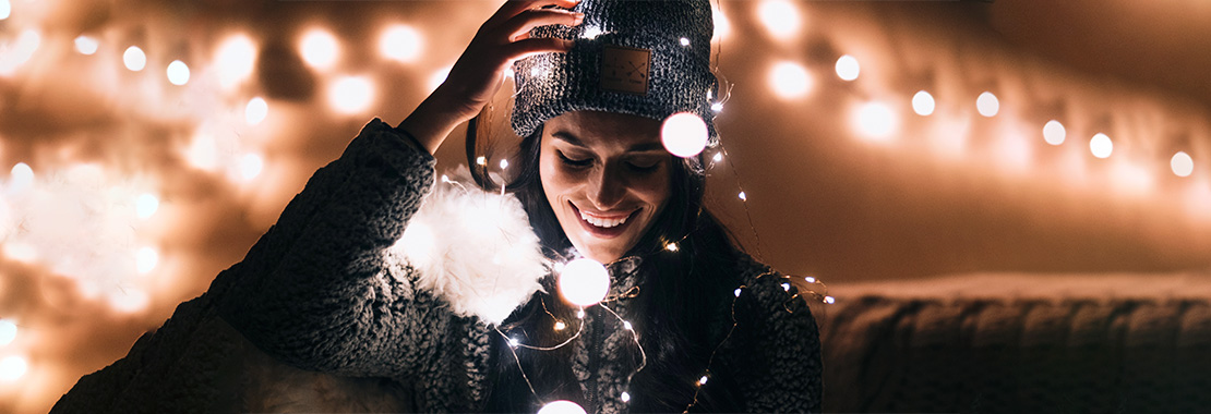 Female student surrounded by bright string lights