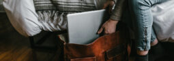 Person packing laptop into shoulder bag