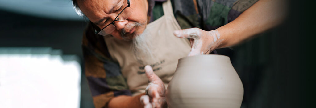 Man making a bowl at a pottery wheel