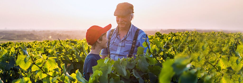 Older man talking to a young boy on a farm.