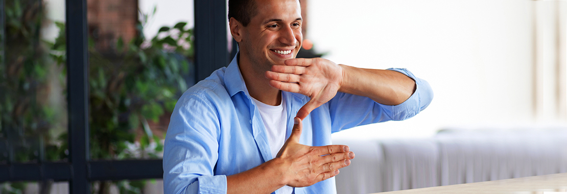 Man smiles while using sign language