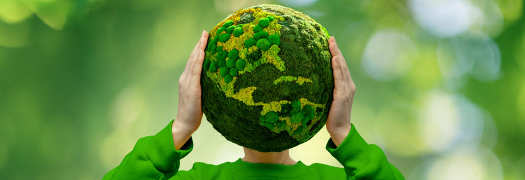 Person holds up a green globe