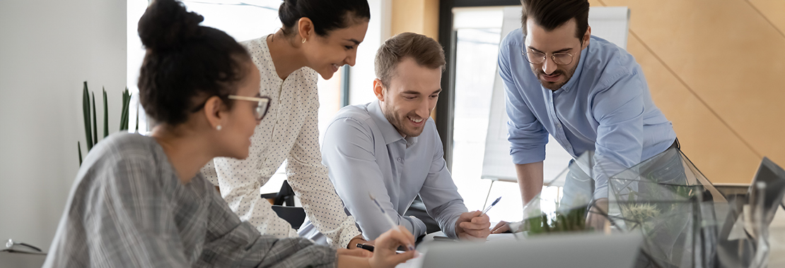 four people work together at a desk