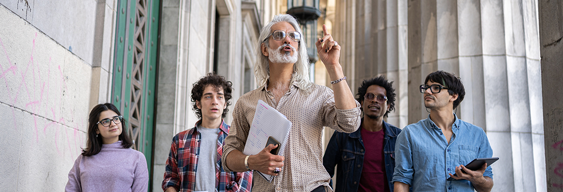 An instructor points up while teaching a group of students