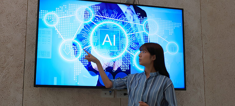 Woman Instructor points to AI presentation on large screen