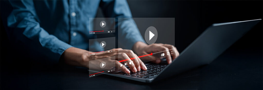 Hands type on a keyboard overlayed with pop-up video screens.