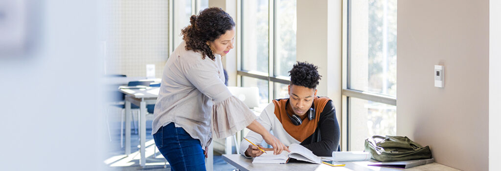 An instructor helps a student with an assignment.