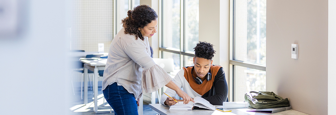 An instructor helps a student with an assignment.